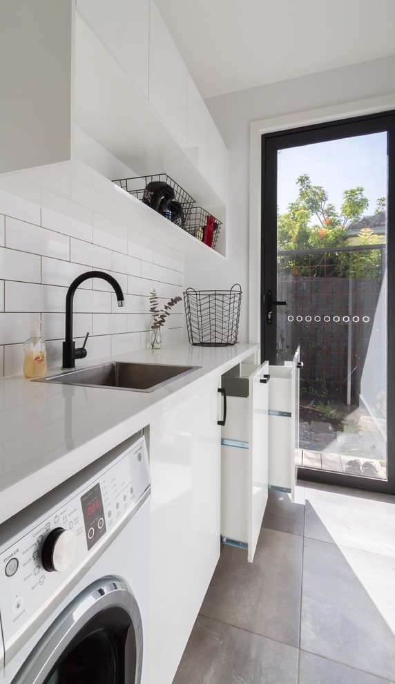 Photo of a mid-sized modern single-wall dedicated laundry room in Melbourne with flat-panel cabinets, white cabinets, quartz benchtops, white walls and ceramic floors.