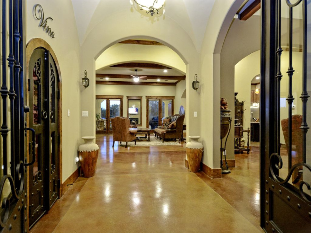Expansive mediterranean foyer in Austin with concrete floors, a double front door and coffered.