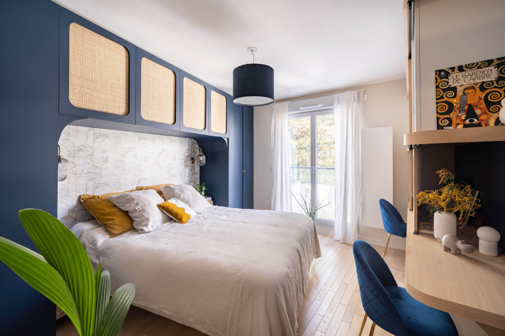 Modelo de dormitorio principal vintage con suelo de madera clara y papel pintado