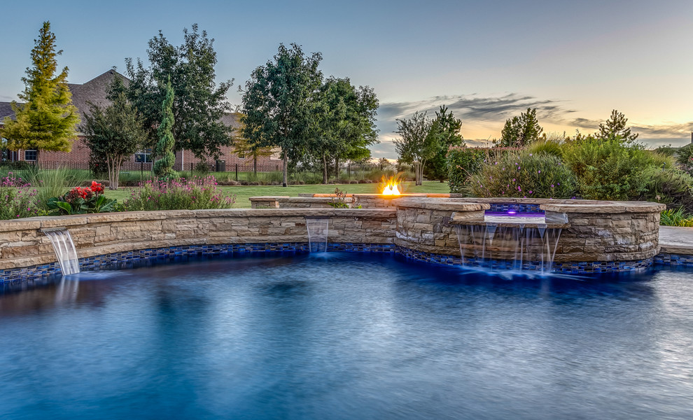 Photo of a large traditional backyard kidney-shaped natural pool in Dallas with a hot tub and tile.