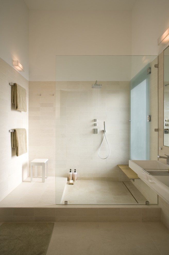 This is an example of a mid-sized modern master bathroom in Austin with an open shower, beige tile, beige walls, limestone floors, a trough sink, an open shower, limestone, beige floor and a shower seat.
