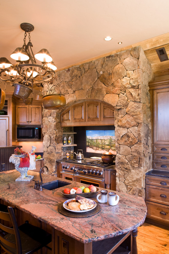 Inspiration for a large country u-shaped eat-in kitchen in Denver with louvered cabinets, distressed cabinets, granite benchtops, beige splashback, stone tile splashback, stainless steel appliances, medium hardwood floors, with island, brown floor and red benchtop.