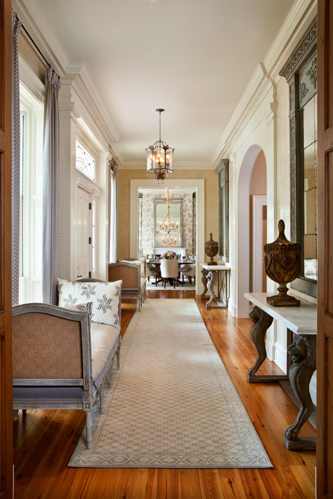 Inspiration for a transitional hallway in Orlando with white walls and medium hardwood floors.