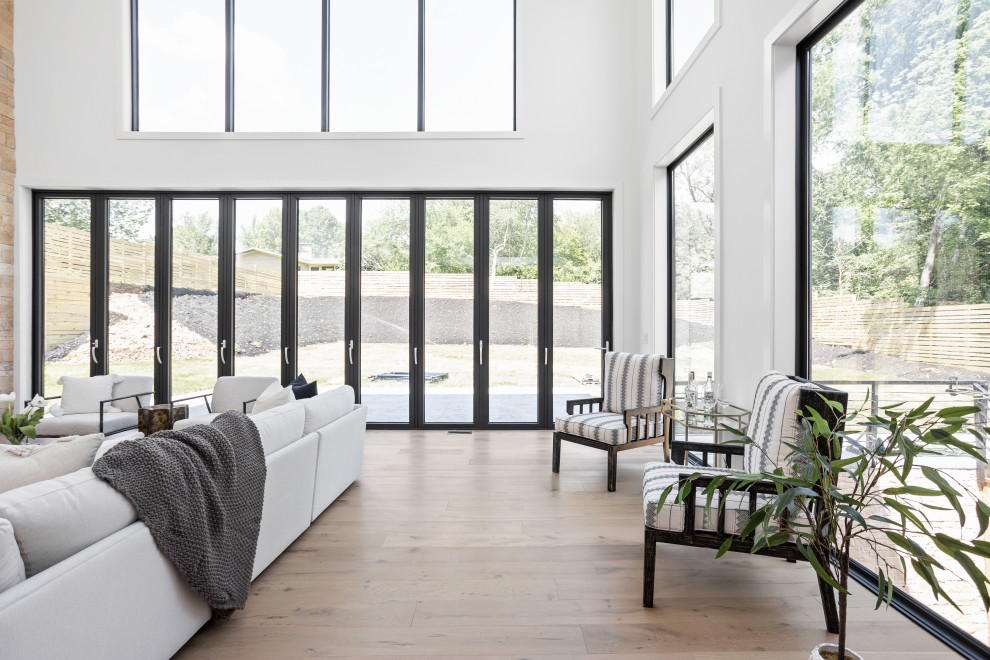 Foto de sala de estar abierta minimalista extra grande con paredes blancas, suelo de madera clara, chimeneas suspendidas, piedra de revestimiento y suelo multicolor