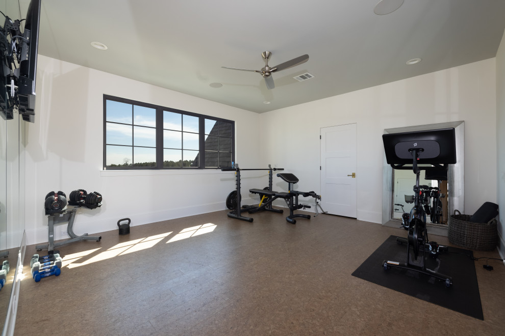 Mid-sized eclectic home weight room in Houston with white walls and brown floor.