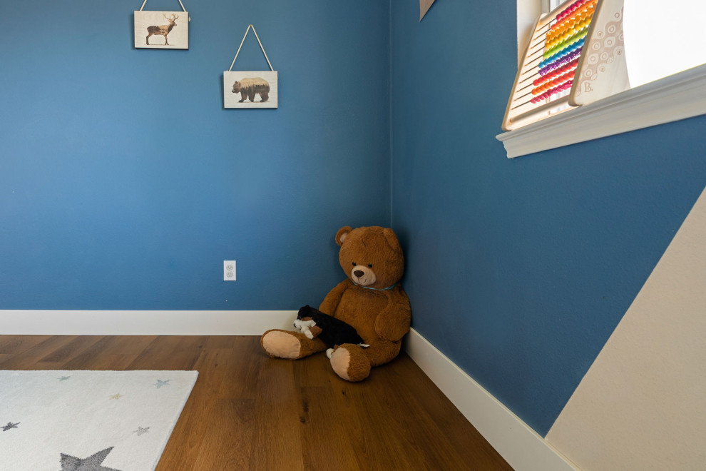 На фото: нейтральная детская с игровой среднего размера в стиле кантри с синими стенами, полом из винила, коричневым полом и сводчатым потолком для ребенка от 4 до 10 лет