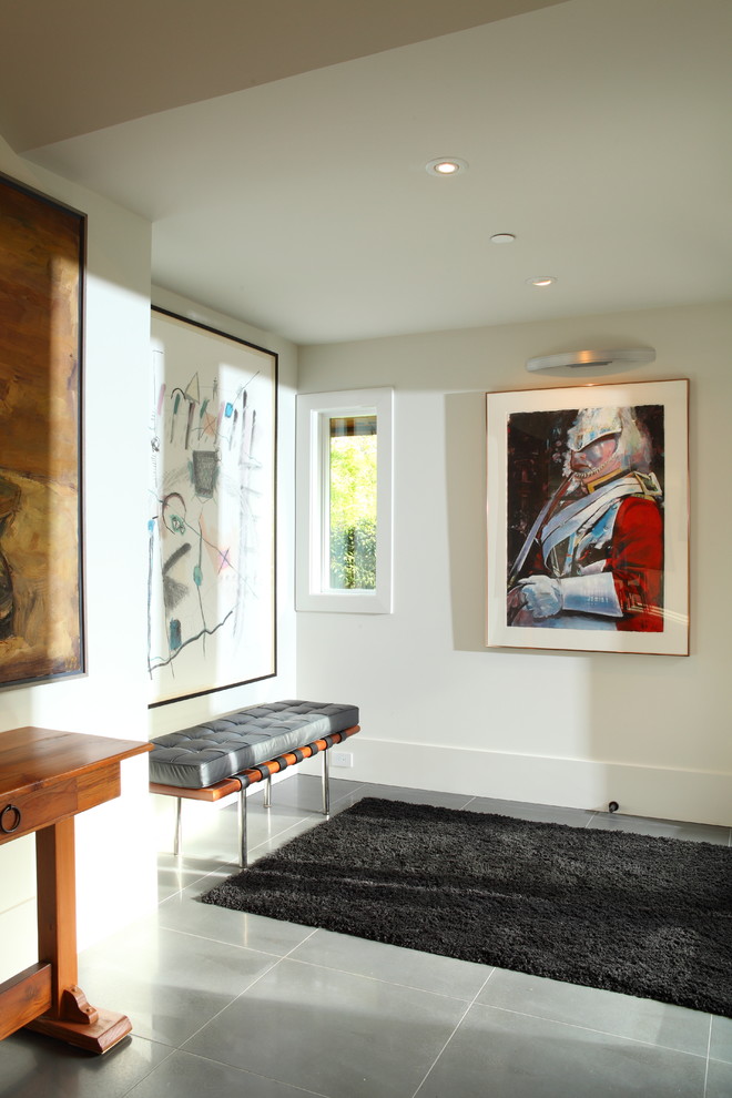 Photo of a contemporary entryway in Vancouver with white walls and grey floor.