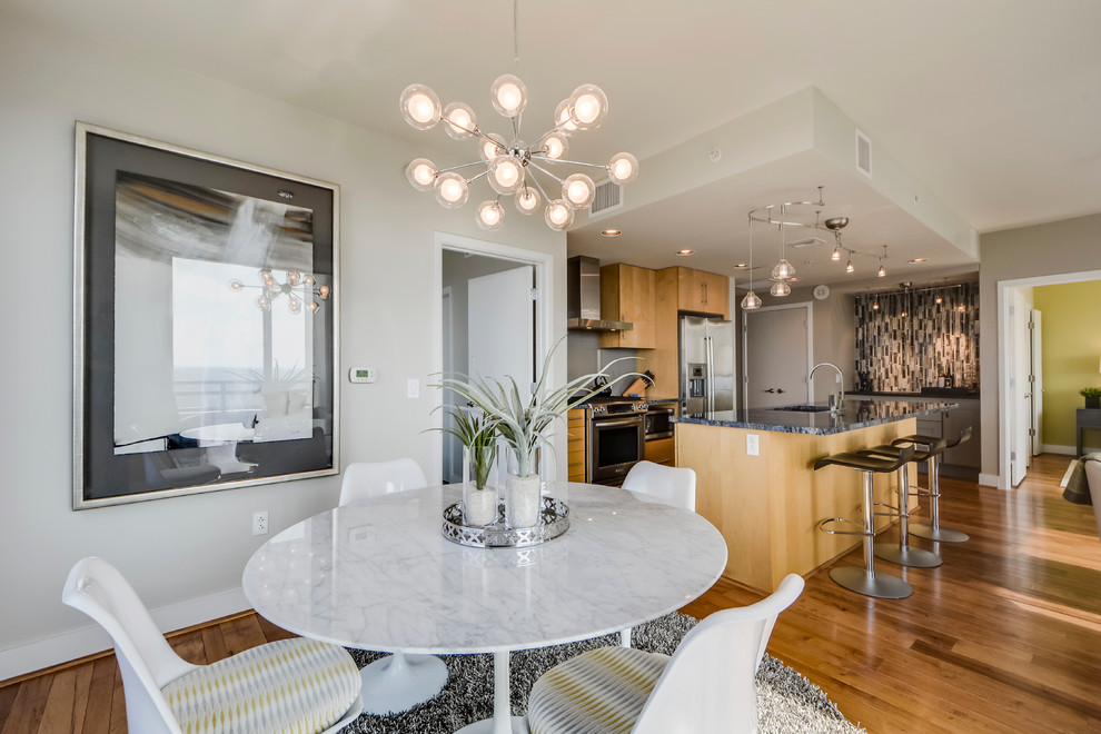 Open concept kitchen - small transitional galley light wood floor open concept kitchen idea in Austin with a double-bowl sink, flat-panel cabinets, light wood cabinets, granite countertops, gray backsplash, porcelain backsplash, stainless steel appliances and an island