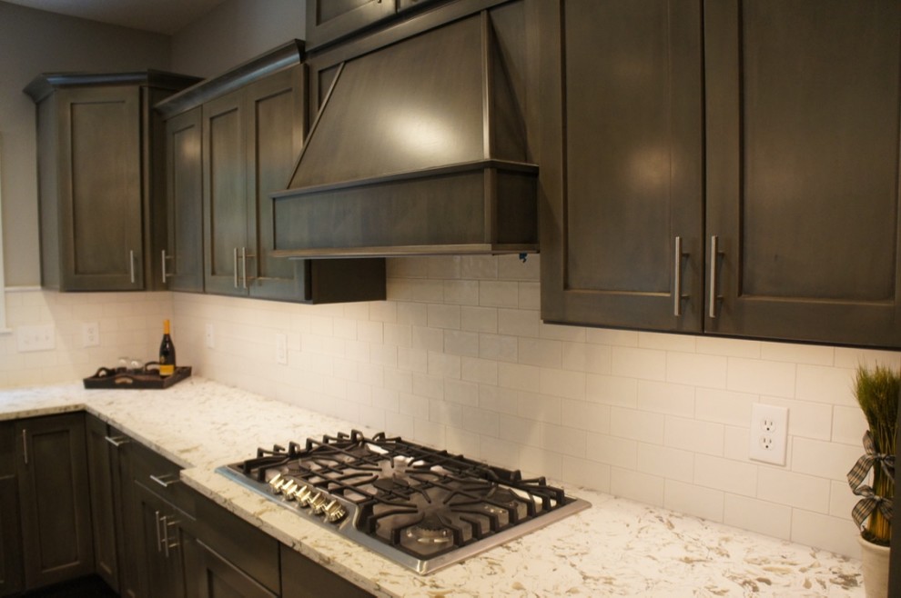 Transitional u-shaped eat-in kitchen photo with a farmhouse sink, flat-panel cabinets, white backsplash, ceramic backsplash, stainless steel appliances and an island