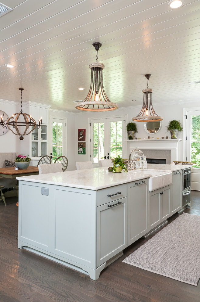Country kitchen in Atlanta with a farmhouse sink, blue cabinets, dark hardwood floors and with island.