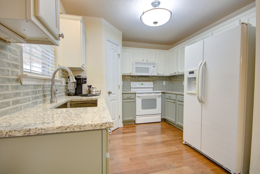 Eat-in kitchen - mid-sized transitional u-shaped medium tone wood floor and brown floor eat-in kitchen idea with an undermount sink, shaker cabinets, green cabinets, granite countertops, green backsplash, ceramic backsplash, white appliances, no island and multicolored countertops