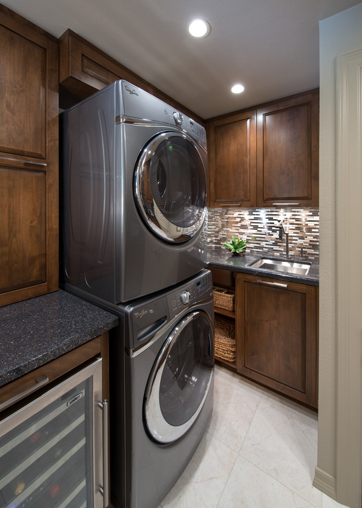 Design ideas for a mid-sized contemporary laundry room in Orange County with an undermount sink, medium wood cabinets, quartz benchtops, a stacked washer and dryer and grey walls.