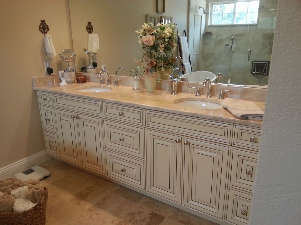 Photo of a mid-sized traditional master bathroom in Tampa with raised-panel cabinets, beige cabinets, a claw-foot tub, an alcove shower, a one-piece toilet, beige tile, ceramic tile, beige walls, travertine floors, an undermount sink and granite benchtops.