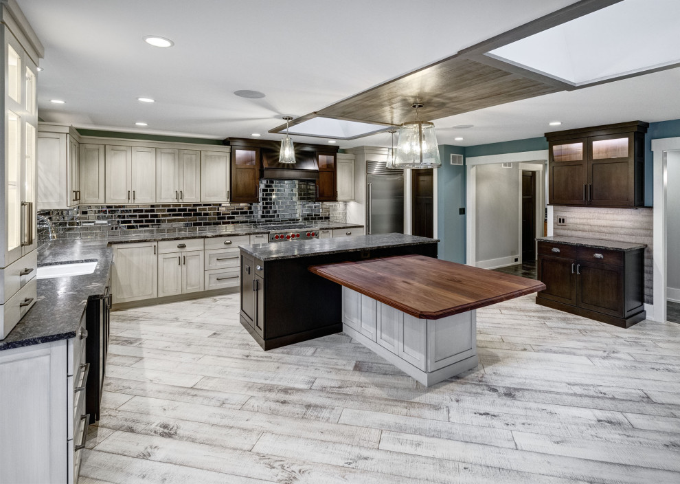 Design ideas for a mid-sized transitional u-shaped eat-in kitchen in Chicago with wood benchtops, light hardwood floors, with island, white floor and wood.