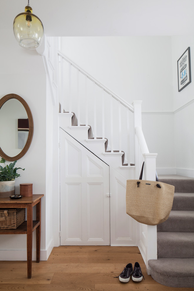 Inspiration for a mid-sized scandinavian entryway in Sussex with white walls, medium hardwood floors and brown floor.