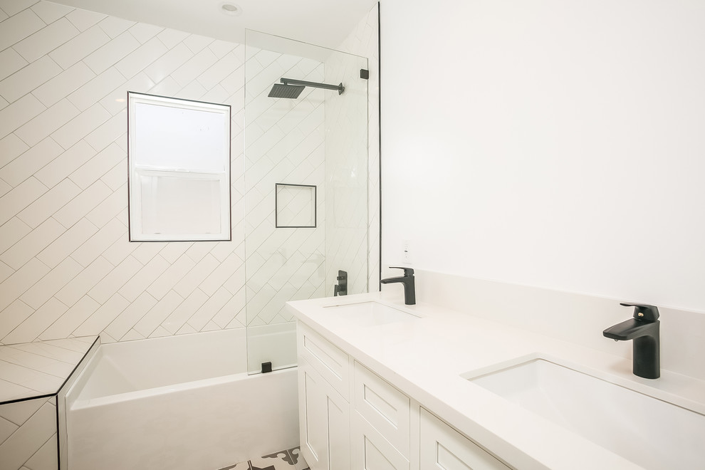 Design ideas for a mid-sized country kids bathroom in Los Angeles with shaker cabinets, white cabinets, a shower/bathtub combo, a two-piece toilet, white tile, subway tile, white walls, cement tiles, an undermount sink, engineered quartz benchtops, white floor and an open shower.