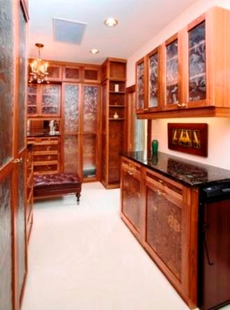 Photo of an expansive traditional walk-in wardrobe in Chicago with glass-front cabinets, beige cabinets and carpet.