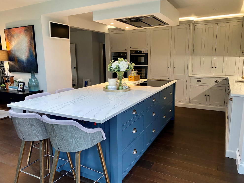 Dark blue kitchen island with white cabinets and integrated hob ...