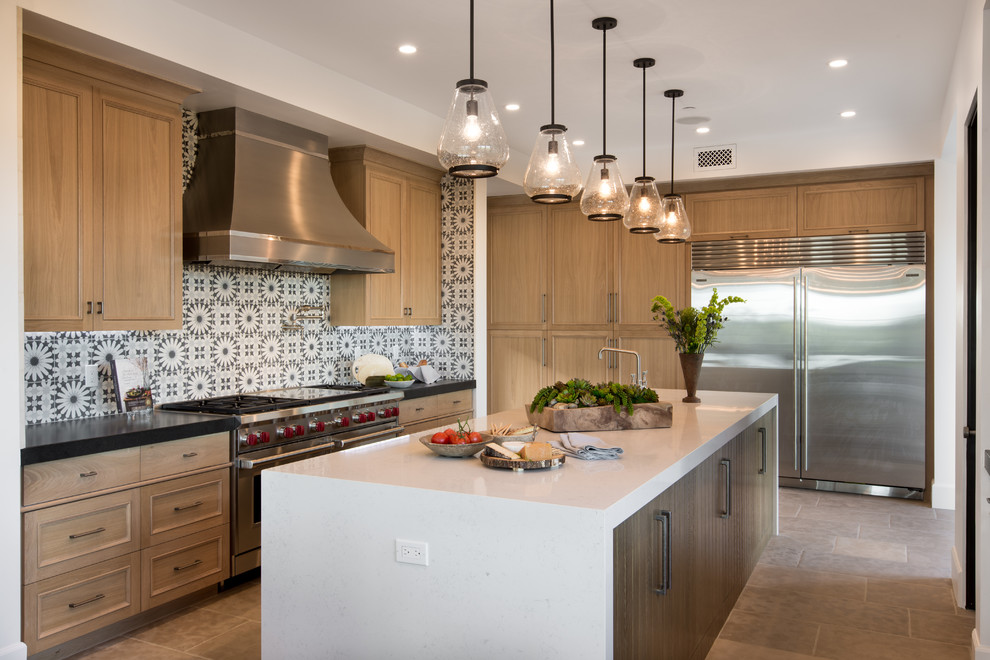 Inspiration for an expansive beach style galley open plan kitchen in Orange County with a drop-in sink, flat-panel cabinets, light wood cabinets, quartz benchtops, blue splashback, cement tile splashback, stainless steel appliances, limestone floors and with island.