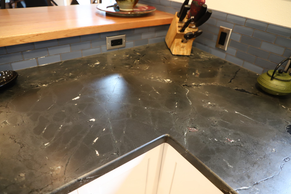 Example of a mid-sized transitional u-shaped medium tone wood floor and brown floor eat-in kitchen design with shaker cabinets, white cabinets, granite countertops, blue backsplash, stainless steel appliances, black countertops, an undermount sink, stone tile backsplash and a peninsula