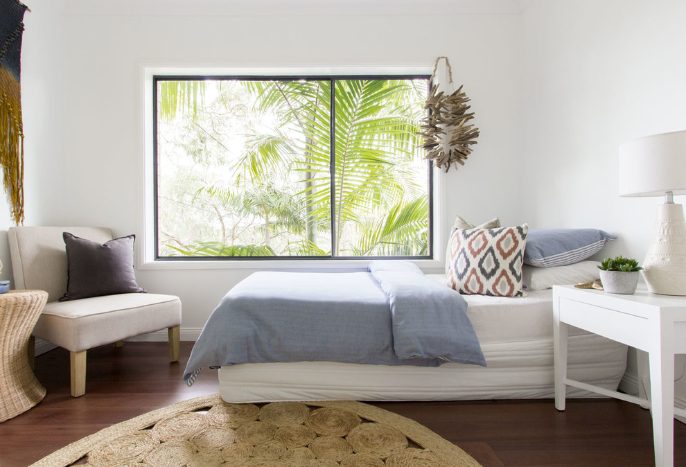 Inspiration for a mid-sized beach style guest bedroom in Sydney with white walls, medium hardwood floors and no fireplace.