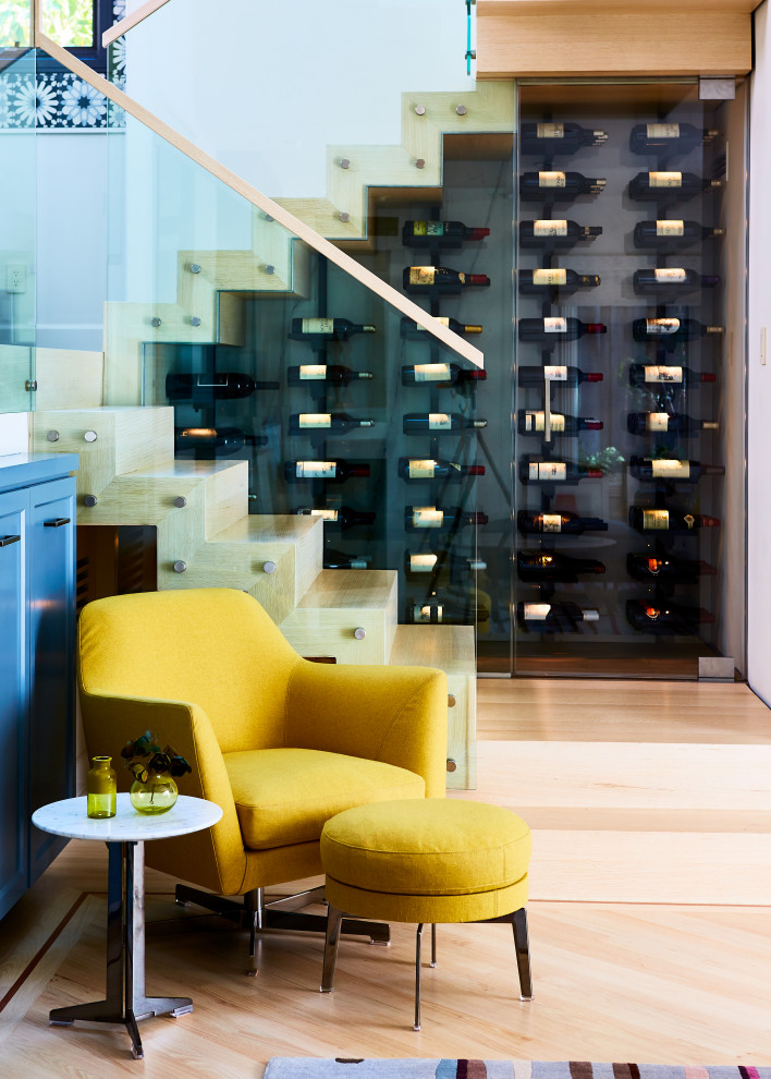 This is an example of a traditional wine cellar in San Francisco with light hardwood floors, display racks and brown floor.