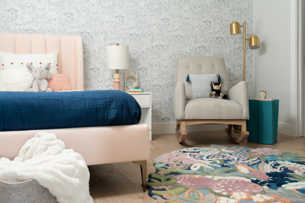 Imagen de habitación de niña de 1 a 3 años moderna con suelo de madera clara y papel pintado