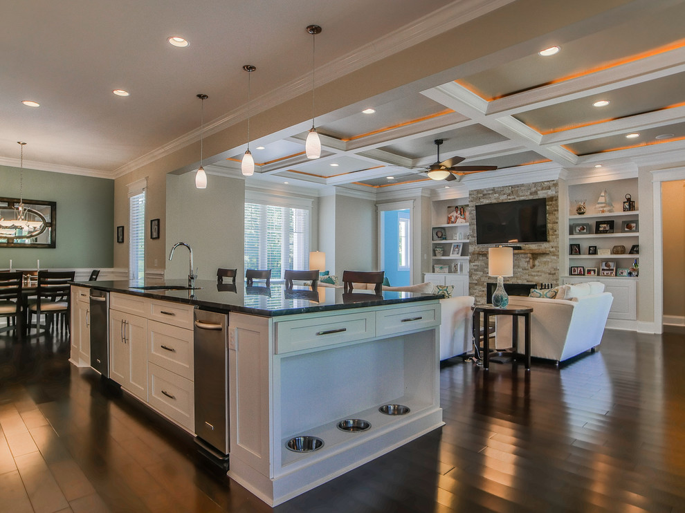 Example of a large transitional dark wood floor and brown floor open concept kitchen design with an undermount sink, shaker cabinets, white cabinets, stainless steel appliances and an island