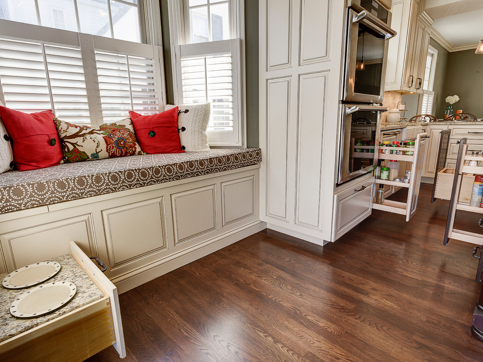 Inspiration for a rustic eat-in kitchen remodel in Columbus with a farmhouse sink, flat-panel cabinets, white cabinets, marble countertops, beige backsplash, stone tile backsplash and stainless steel appliances