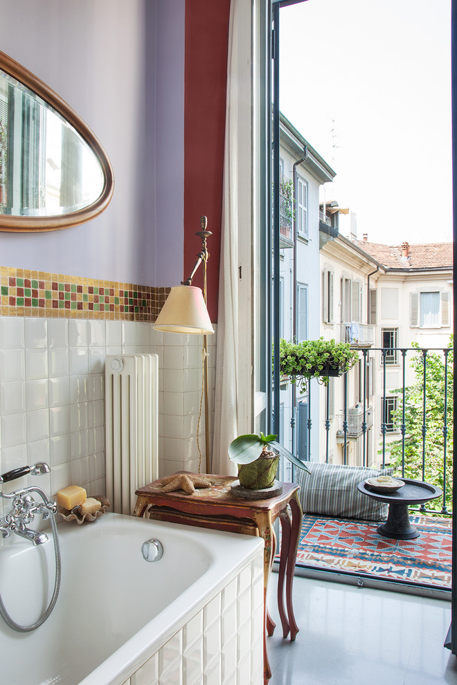Eclectic bathroom in Milan with a drop-in tub, white tile, subway tile and purple walls.