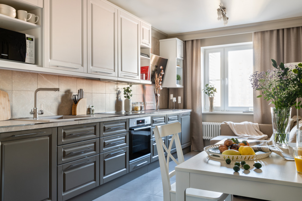 Design ideas for a transitional single-wall eat-in kitchen in Moscow with a drop-in sink, raised-panel cabinets, grey cabinets, beige splashback, stainless steel appliances, no island and beige benchtop.