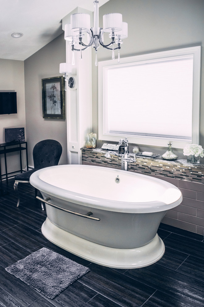 Transitional master brown tile and glass tile dark wood floor and brown floor freestanding bathtub photo in New York with recessed-panel cabinets, white cabinets, a two-piece toilet, gray walls, an undermount sink, granite countertops, a hinged shower door and multicolored countertops