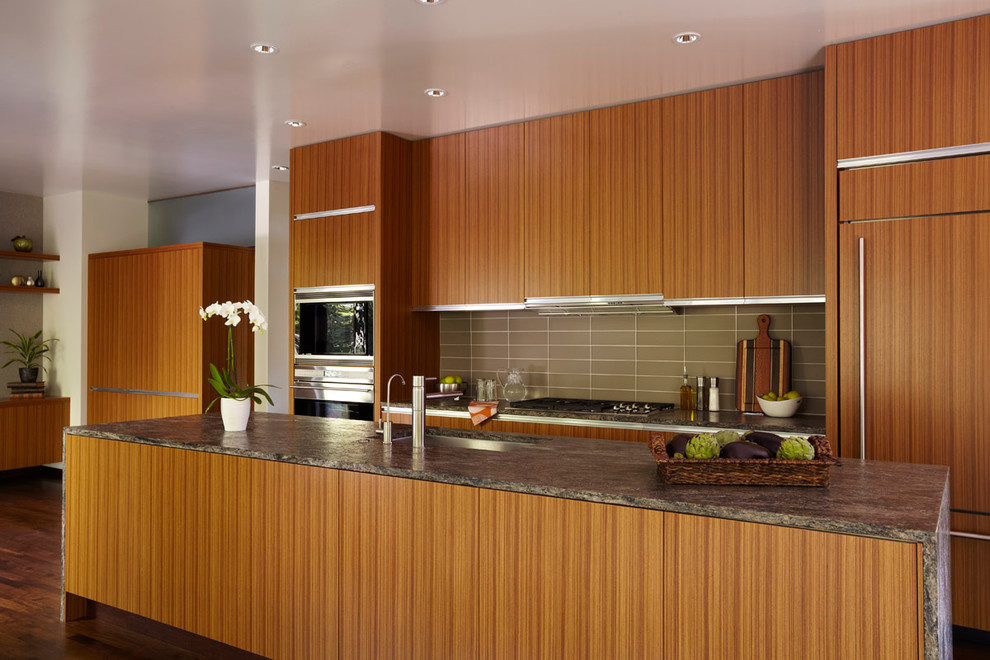 This is an example of a modern galley kitchen in Minneapolis with panelled appliances, flat-panel cabinets and medium wood cabinets.