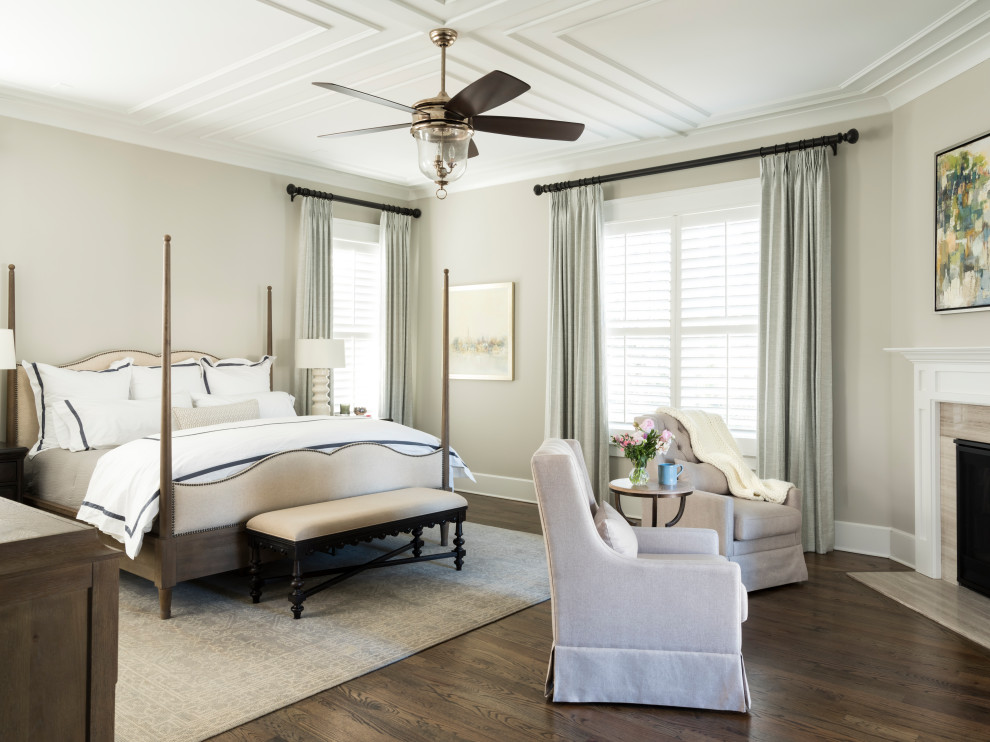 This is an example of a transitional master bedroom in Atlanta with beige walls, medium hardwood floors, a corner fireplace, a stone fireplace surround and brown floor.