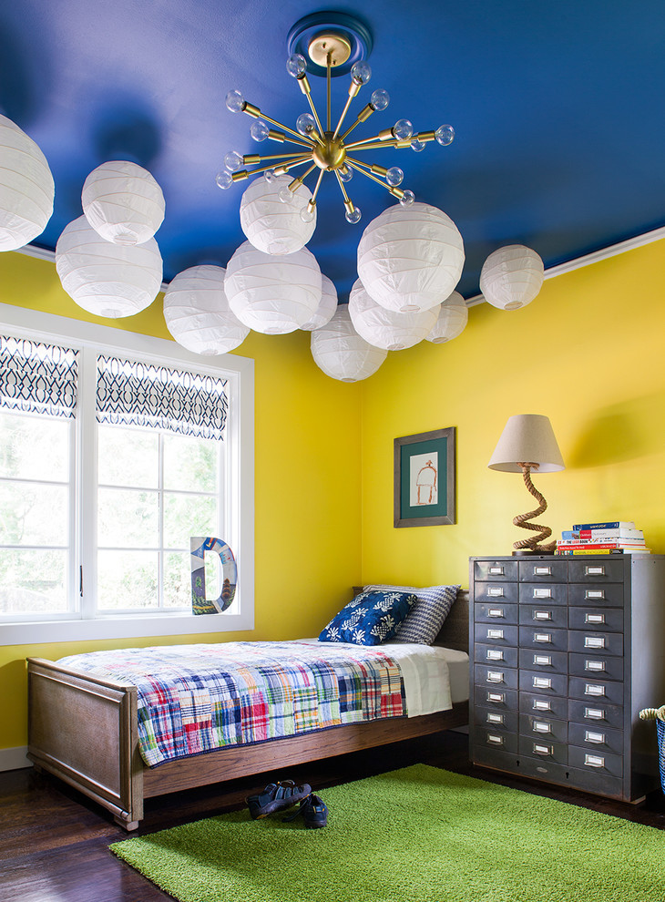 This is an example of a transitional kids' bedroom for kids 4-10 years old and boys in Atlanta with yellow walls and dark hardwood floors.
