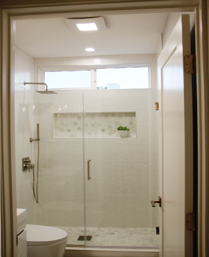 Photo of a medium sized contemporary grey and white family bathroom in Atlanta with flat-panel cabinets, white cabinets, a built-in shower, a two-piece toilet, white tiles, ceramic tiles, blue walls, medium hardwood flooring, an integrated sink, engineered stone worktops, brown floors, a hinged door, white worktops, a wall niche, a single sink and a floating vanity unit.