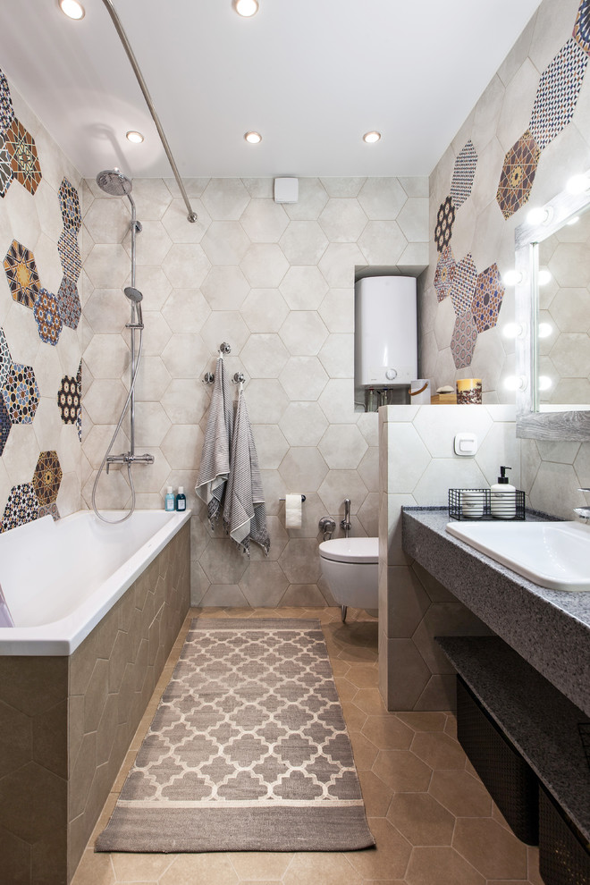 Design ideas for a mediterranean 3/4 bathroom in Moscow with open cabinets, a drop-in tub, a shower/bathtub combo, a wall-mount toilet, multi-coloured tile, cement tile, a drop-in sink, beige floor, a shower curtain and grey benchtops.