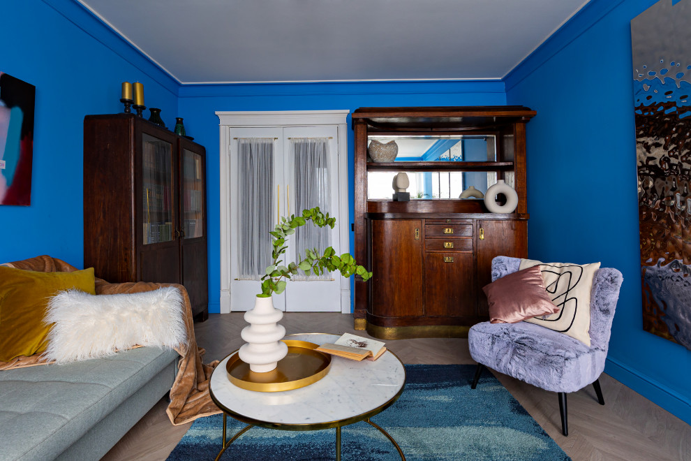 На фото: маленькая изолированная гостиная комната в стиле модернизм с синими стенами, полом из ламината и бежевым полом для на участке и в саду с