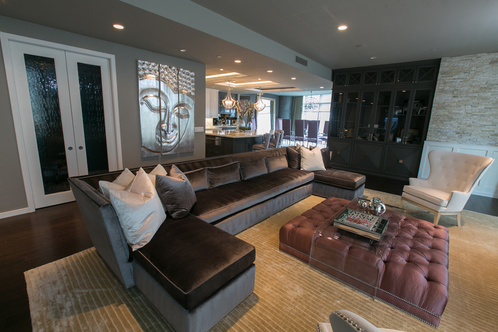 Example of a large transitional formal and open concept dark wood floor living room design in Austin with gray walls and a media wall