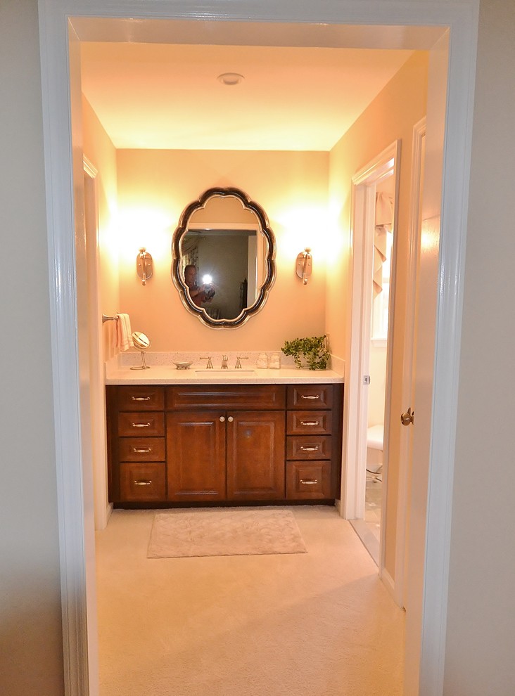Photo of a mid-sized traditional master bathroom in Philadelphia with recessed-panel cabinets, medium wood cabinets, a corner shower, a one-piece toilet, beige tile, ceramic tile, ceramic floors, an undermount sink, granite benchtops, beige floor and a hinged shower door.