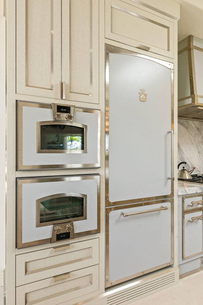 Modern inredning av ett mycket stort vit vitt kök, med en integrerad diskho, skåp i rostfritt stål, marmorbänkskiva, vitt stänkskydd, stänkskydd i marmor, vita vitvaror, flera köksöar och beiget golv