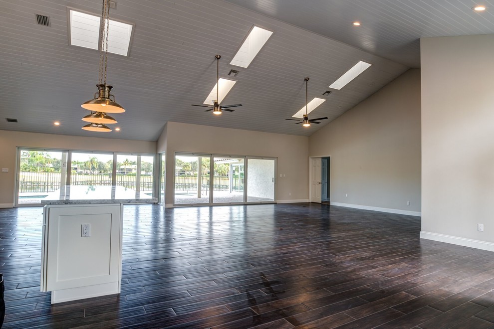 Family room - large contemporary open concept dark wood floor family room idea in Columbus with beige walls, no fireplace and no tv
