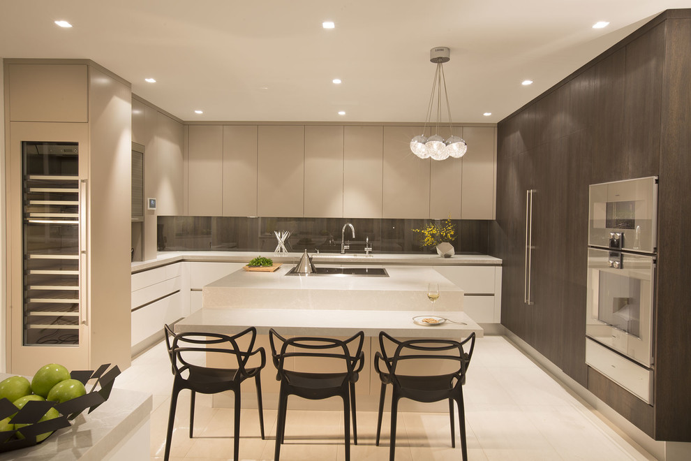 Contemporary u-shaped eat-in kitchen in Miami with stainless steel appliances and with island.