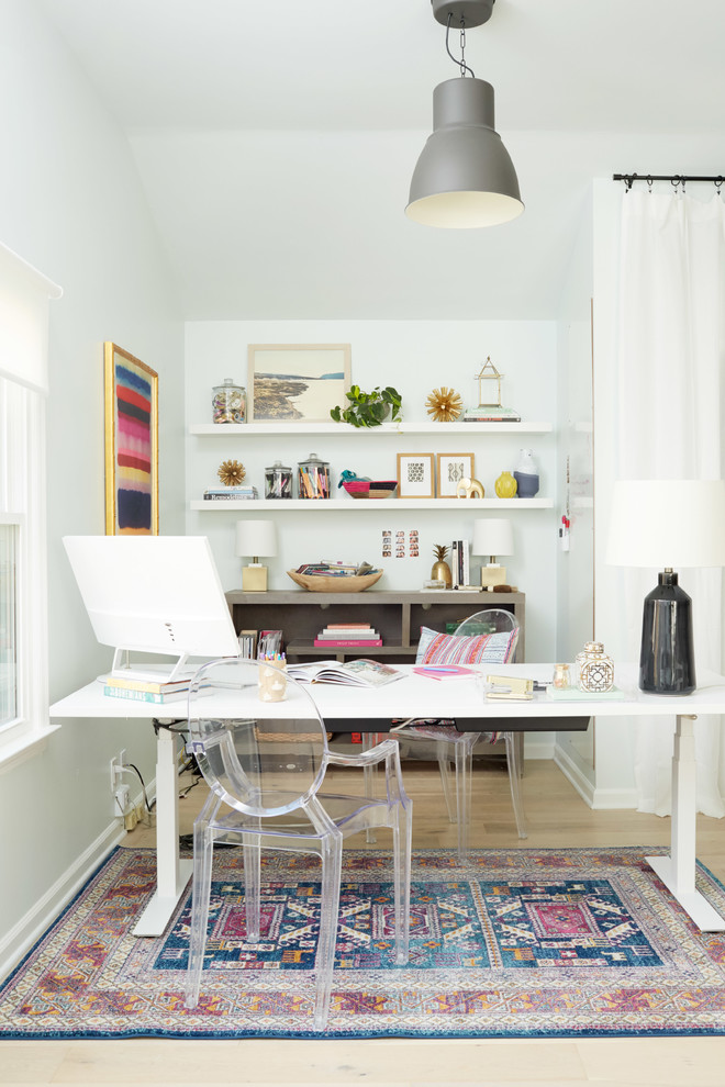 Inspiration for an eclectic home office in Nashville with white walls, light hardwood floors, a freestanding desk and beige floor.