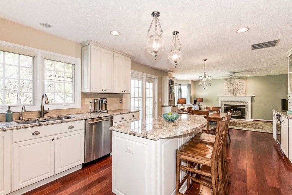 Eat-in kitchen - mid-sized transitional u-shaped medium tone wood floor and brown floor eat-in kitchen idea in Baltimore with an undermount sink, raised-panel cabinets, white cabinets, granite countertops, beige backsplash, porcelain backsplash, stainless steel appliances and an island