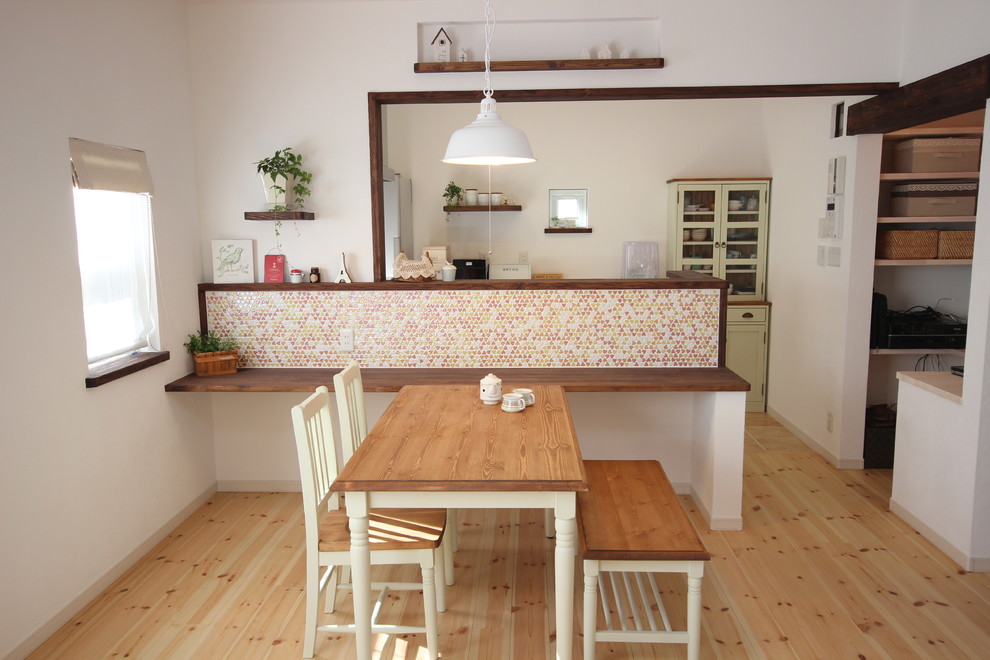 Mid-sized scandinavian kitchen/dining combo in Other with white walls and light hardwood floors.
