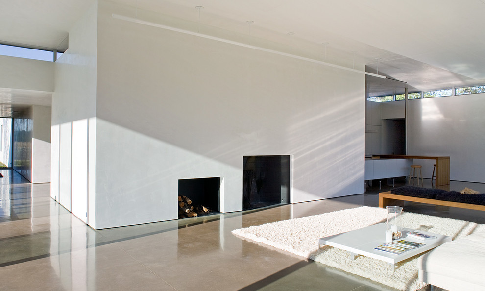 This is an example of a modern open concept living room in Other with white walls, concrete floors, a standard fireplace, a plaster fireplace surround and grey floor.