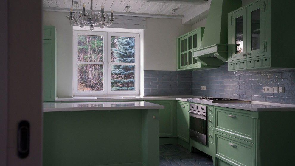 Inredning av ett 50 tals stort vit vitt kök, med luckor med upphöjd panel, gröna skåp, bänkskiva i koppar, blått stänkskydd, stänkskydd i porslinskakel, klinkergolv i porslin, en köksö och blått golv