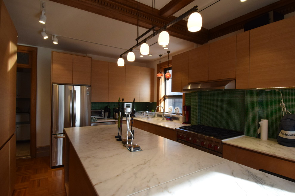 Mid-sized midcentury u-shaped eat-in kitchen in New York with an undermount sink, flat-panel cabinets, light wood cabinets, marble benchtops, green splashback, glass tile splashback, stainless steel appliances, light hardwood floors and with island.
