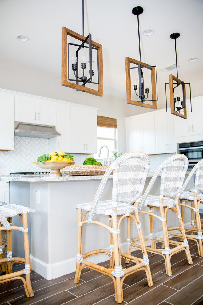 Inspiration for a mid-sized transitional u-shaped ceramic tile and brown floor open concept kitchen remodel in Phoenix with a single-bowl sink, shaker cabinets, white cabinets, granite countertops, white backsplash, subway tile backsplash, stainless steel appliances and an island